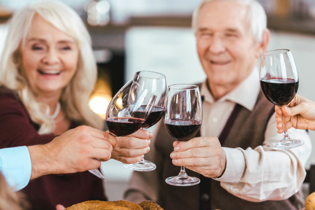 una pareja de ancianos brindando con su familia durante la celebración de las fiestas