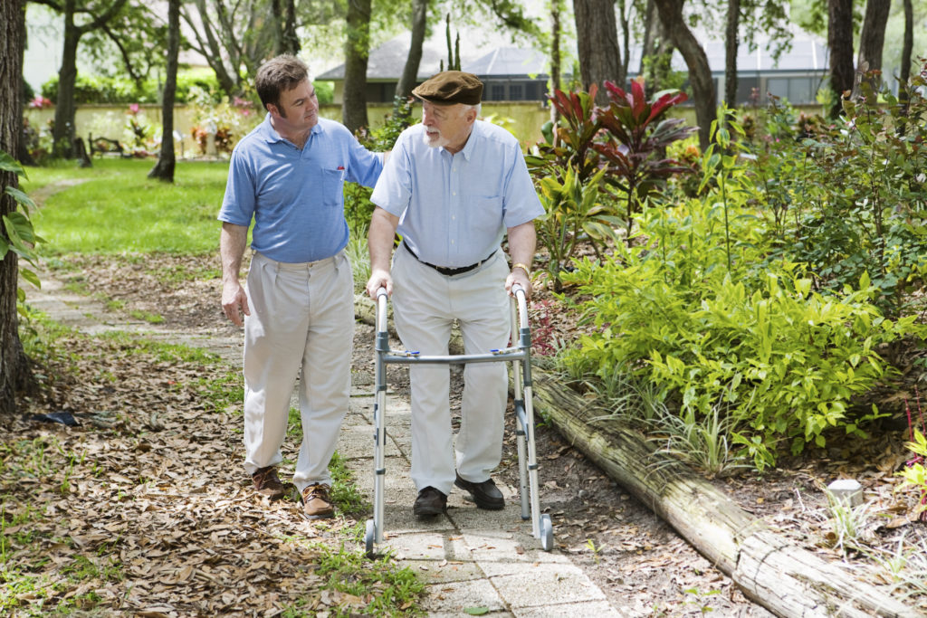 Anciano dando un paseo por la comunidad con su cuidador