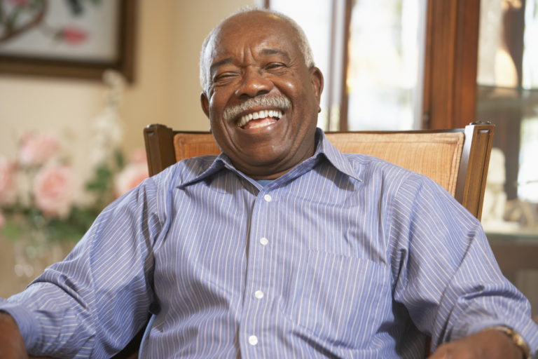 Senior man relaxing in armchair as he smiles at the camera