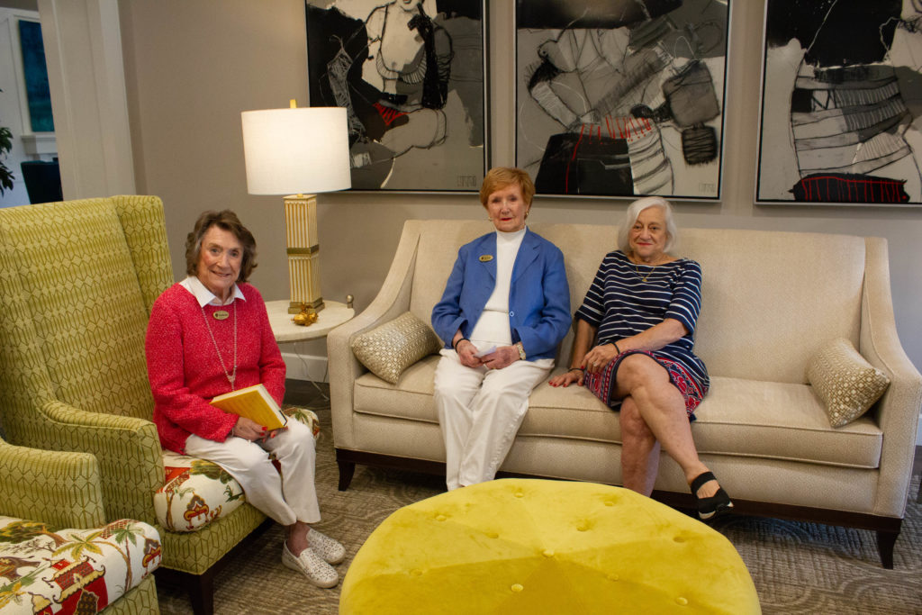 Three residents in a common area chatting and smiling at the camera