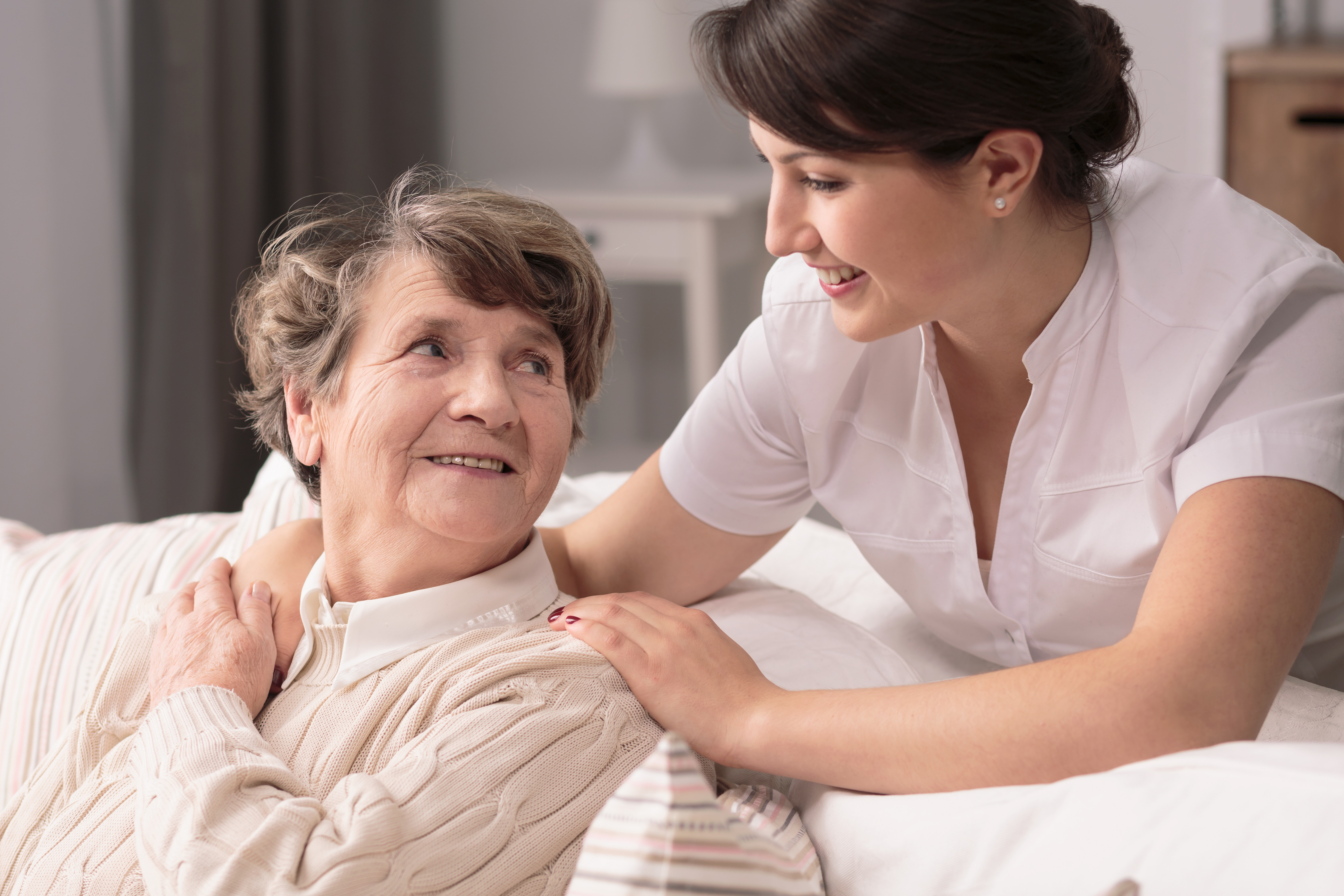 Caregiver with hands on the shoulder of senior woman