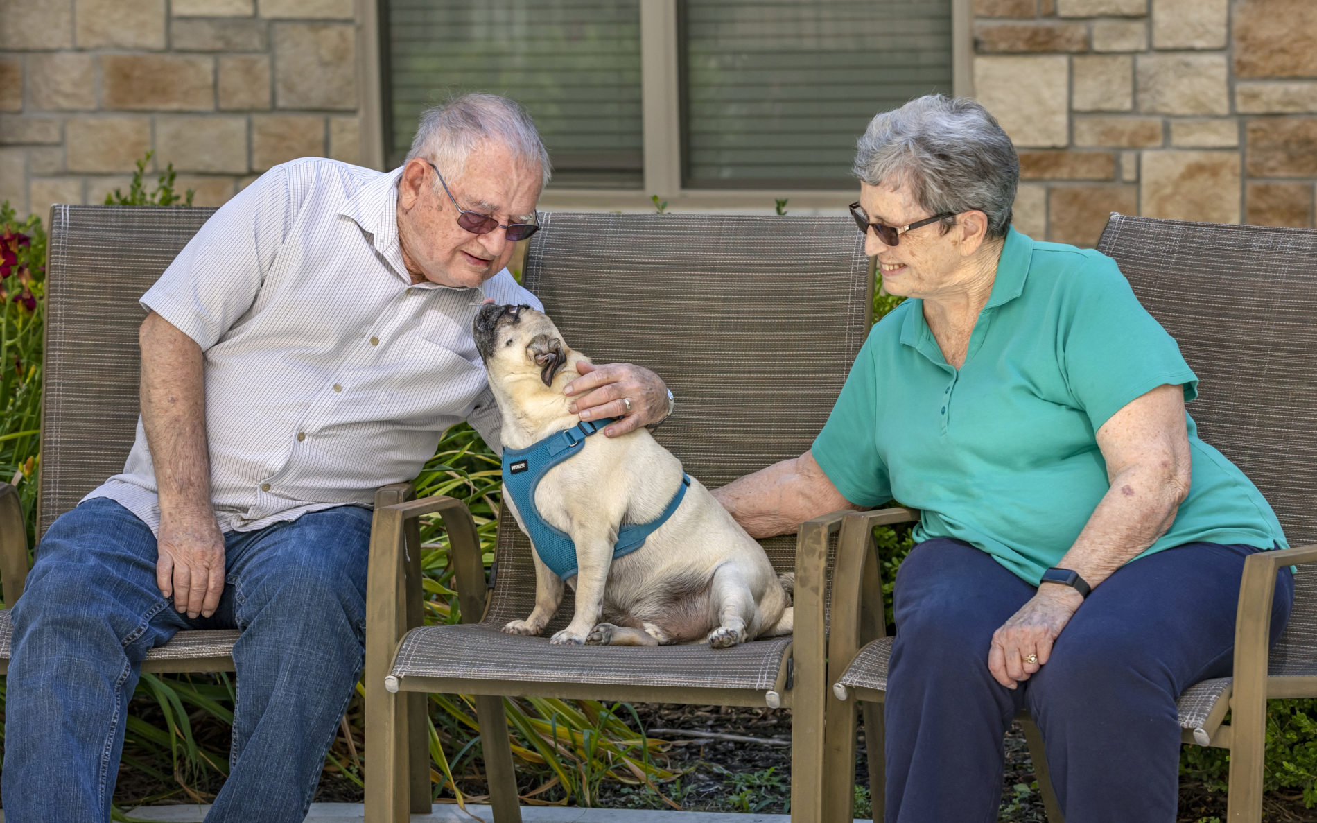 Elderly couple sitting in chairs with dog