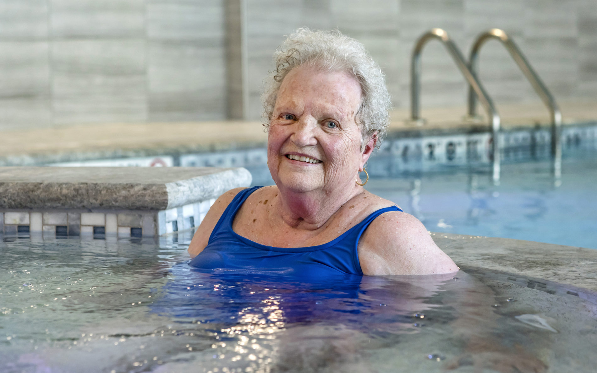 Elderly woman smiling while in jacuzzi
