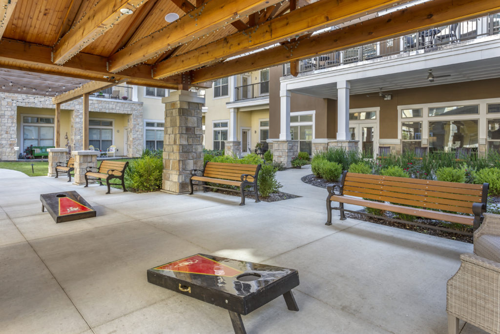 Senior living community outdoor area with benches and bag toss game
