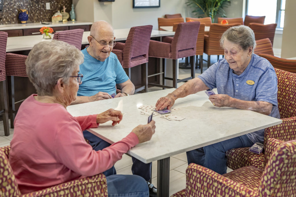 Seniors playing cards around table